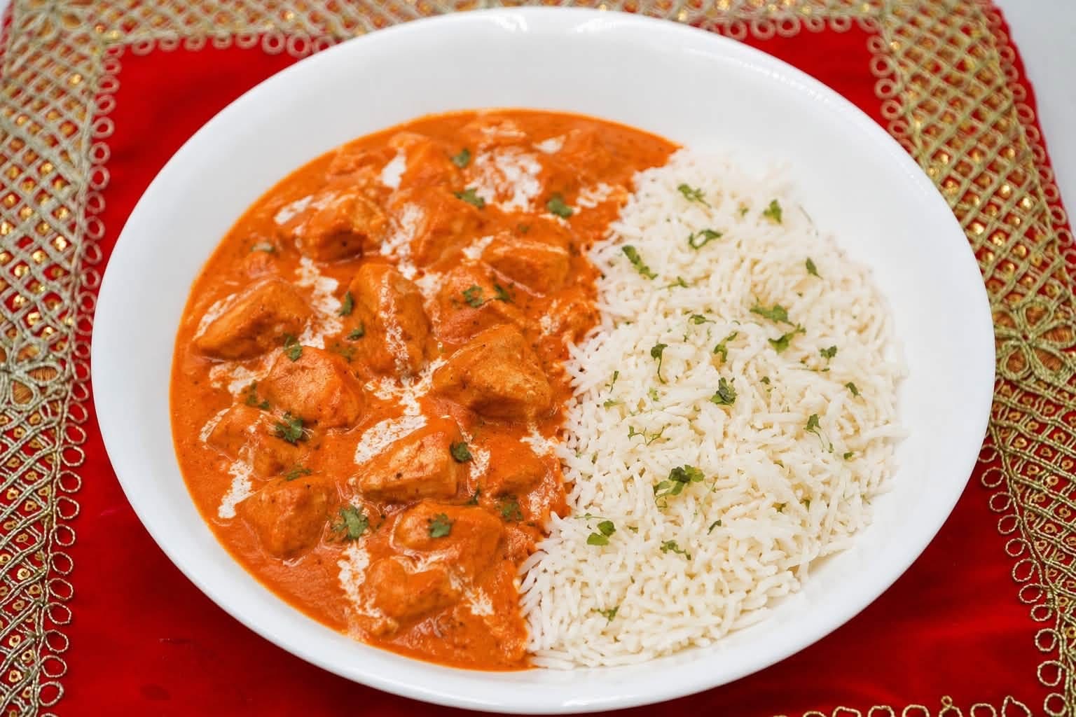 Chicken tikka masala with basmati rice in a white bowl